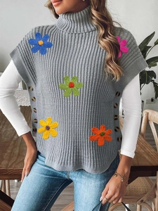 Detail of grey ribbed knit vest with colorful crochet flowers and side wood buttons