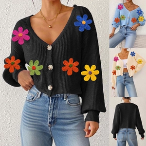 Détail du cardigan en maille à col en V avec broderie florale 3D et boutons effet marbre