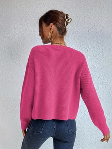 Detail view of the vertical ribbed texture and drop shoulder on hot pink knit sweater