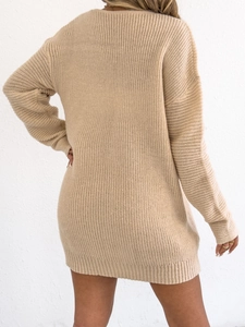 Detail of beige knit sweater dress showing vertical ribbed texture and loose fit design