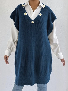 Close-up of crochet floral patchwork on dark blue knit V-neck vest for women