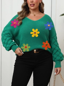Detailed view of the green V-neck sweater with textured bubble sleeves and floral appliques