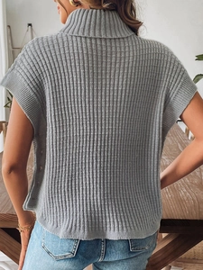 Dettaglio del gilet grigio a collo alto con trama a costine verticali e retro senza maniche