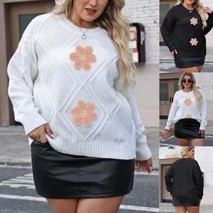 Close-up of diamond pattern knitting and delicate 3D daisy embroidery on the sweater