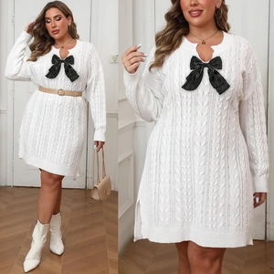 Detail of cable knit white sweater dress with a large black bow and V-neckline texture