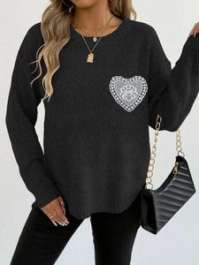 Detalle de elegante parche de encaje blanco con forma de corazón en suéter negro