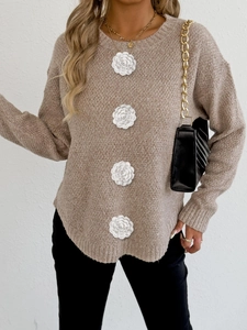 Détail du pull en maille avoine avec fleurs en crochet 3D sur les manches longues