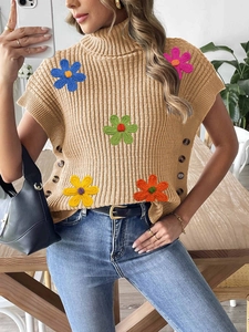 Detail of knit vest showing colorful 3D flower appliques and side button accents