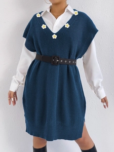 Detail of dark blue knit vest dress featuring V-neck and white daisy floral embroidery
