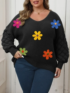Detail of colorful 3D crochet flowers and lantern sleeves on a black V-neck sweater