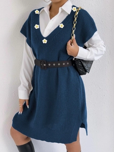 Close-up of knit texture and white daisy appliques on a navy V-neck vest dress