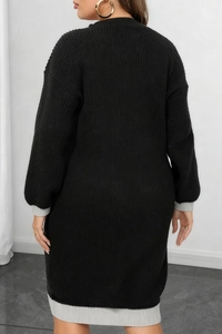 Detail view of the back of a black knitted dress with grey ribbed cuffs and hemline