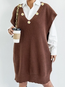 Close-up of brown crochet knit vest with white floral patches and V-neckline detail