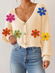 Détails des fleurs au crochet 3D colorées sur un cardigan en maille de couleur crème
