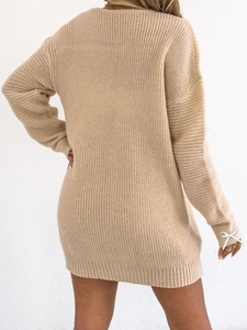 Rear view of light brown knit sweater dress showing clean texture and cuff bow details