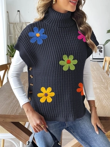 Close-up of colorful crochet flower embroidery and button details on knit sweater vest