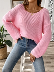 Close-up of pink oversized knit sweater with wide neckline and flared sleeves texture