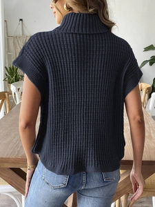 Dettaglio del retro di un gilet in maglia blu scuro con collo alto e trama a coste