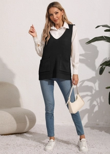 Detail of V-neck knit vest with front pockets layered over a white shirt and blue jeans