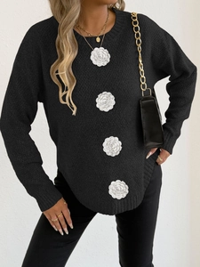 Détail de fleurs en tissu 3D sur un pull en tricot noir à manches longues pour femmes