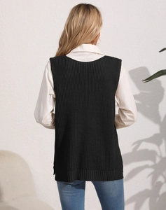Back view of a long black cable knit vest for women with side slits over a white shirt