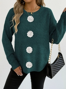 Détail du pull en maille vert foncé avec des fleurs en crochet 3D blanches élégantes