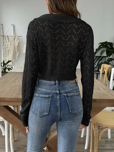 Detail view of black hollow out knit long sleeve crop top with diamond texture from the back