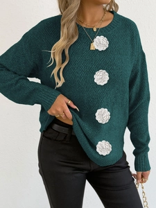 Vue détaillée du pull en maille vert foncé avec décorations uniques de fleurs blanches en 3D