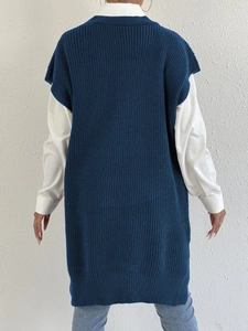 Vista posteriore del gilet lungo in maglia blu scuro con trama verticale su camicia bianca