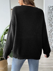 Détail d'un pull noir oversize en grosse maille côtelée avec une coupe décontractée