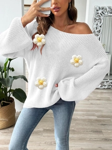 Detailed macro view of 3D crochet flower patches on an off-shoulder knit sweater