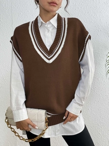 Detail of V-neck knitted vest with white stripe accents on the collar and armholes