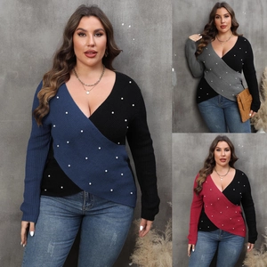 Detail of plus size wrap sweater with deep V-neck, color blocking and pearl accents