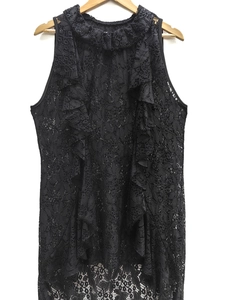 Detail of black lace sleeveless top featuring ruffled collar and hollow floral texture