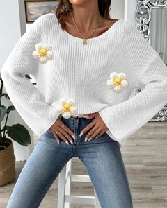Detail of white knit sweater with 3D crochet flowers and elegant off-shoulder neckline