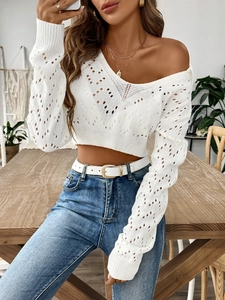 Detail of white hollow knit cropped sweater with V-neckline and diamond pattern