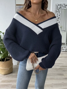 Détail d'un pull en maille bleu marine avec grand col en V et rayures contrastées blanches