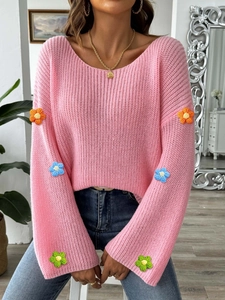 Rosa Strickpullover mit bunten Häkelblumen-Patches und ausgestellten Ärmeln am Model