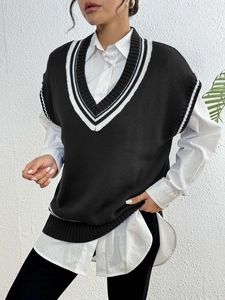 Detail of V-neck knit sweater vest featuring classic black and white contrast striped trim