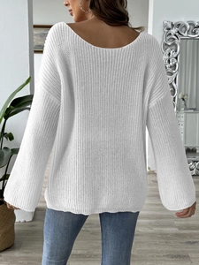 Detailed back view of a white off-shoulder knit sweater with a deep V-neck and flared sleeves