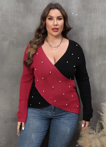 Detail of color-block knit sweater with deep V-neck and delicate pearl bead accents