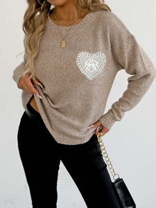 Detalle de aplique de encaje blanco en forma de corazón en jersey de punto marrón claro