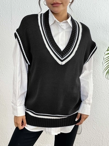 Detailed close-up of V-neck knitted vest with contrast white stripes on black fabric