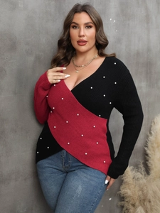Detail of red and black color-block V-neck sweater with white pearl embellishments