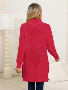 Detail of red cable-knit sweater dress showing high turtleneck and side slit design