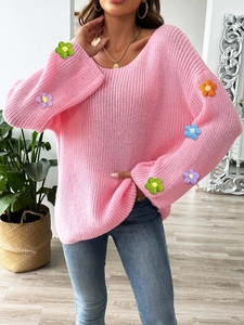 Detail bunter 3D-Häkelblumen am Ärmel des rosa Strickpullovers mit lockerer Passform