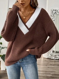 Détail du pull en maille marron à col en V ample avec des rayures blanches et texture