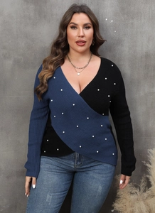 Close-up of deep V-neck knit sweater featuring color block design and pearl beads detail
