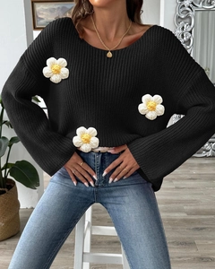 Detail of 3D crochet flower appliqués on a black chunky knit sweater for women
