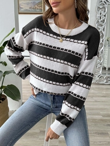 Close-up detail of black and white striped knit sweater with ribbed cuffs and soft texture